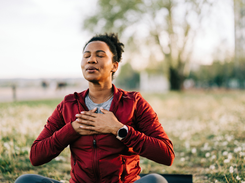 black woman, breath and hand on chest, for meditation and wellness being peaceful to relax. bokeh, african american female and lady outdoor, in nature and being calm for breathing exercise and health