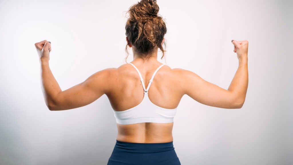 woman flexing back muscles showing strong body