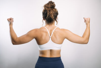 woman flexing back muscles showing strong body