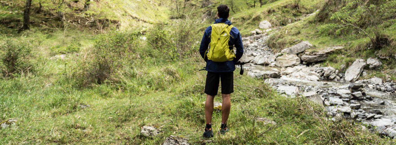 Cerrar senderismo hombre con botas de trekking caminando en el bosque